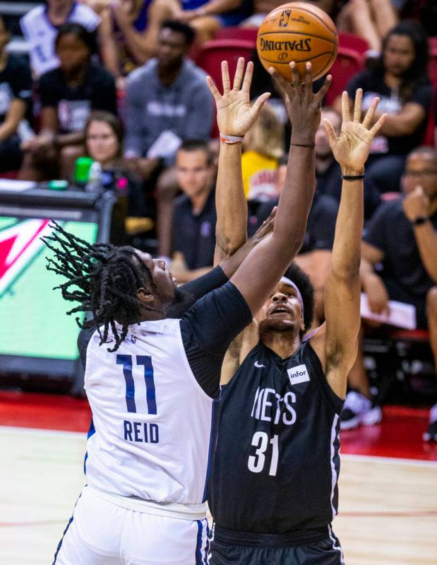 Minnesota Timberwolves center Naz Reid, left, gets off a shot over the Brooklyn Nets center Jar ...