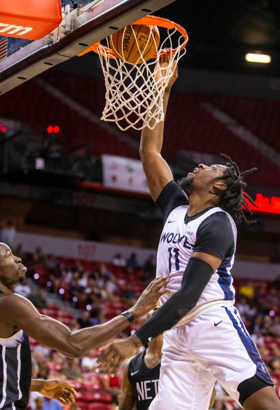 Minnesota Timberwolves center Naz Reid, right, dunks the ball over the Brooklyn Nets guard Jayl ...