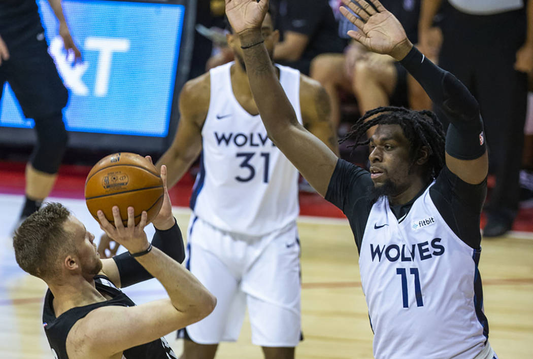 Brooklyn Nets guard Dzanan Musa, left, falls back on a shot attempt as Minnesota Timberwolves c ...