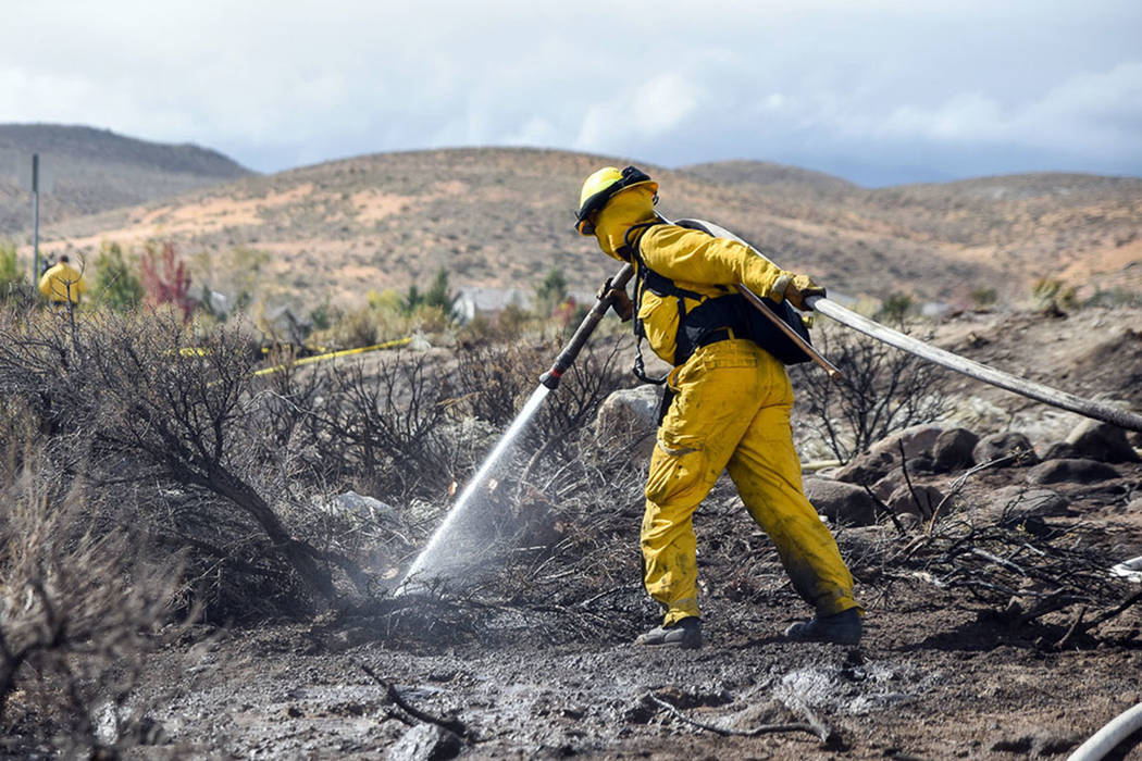 A firefighter hoses down an area in Reno in October 2016. (Mike Higdon/The Reno Gazette-Journal ...