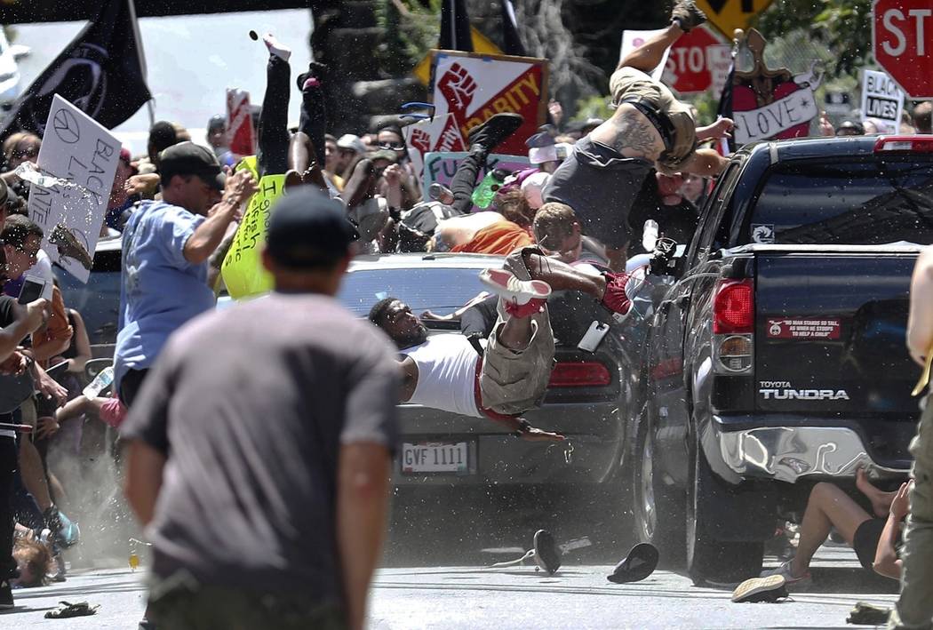 FILE - In this Aug. 12, 2017, file photo, people fly into the air as a vehicle is driven into a ...