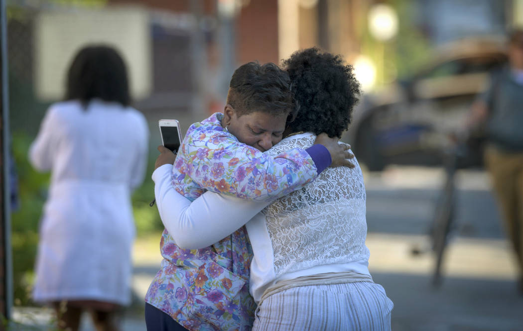 Two women embrace in an alley behind the Man Alive drug treatment center shortly after a shooti ...