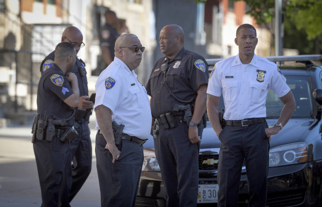 Baltimore Police commissioner Michael Harrison, center left, stands near the scene of a shootin ...