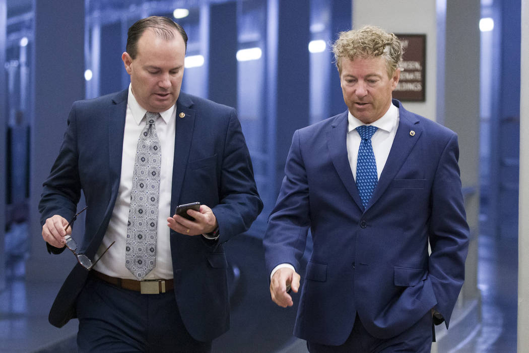 Sen. Mike Lee, R-Utah, and Sen. Rand Paul, R-Ky., walk to a vote on Capitol Hill, Thursday, Jun ...