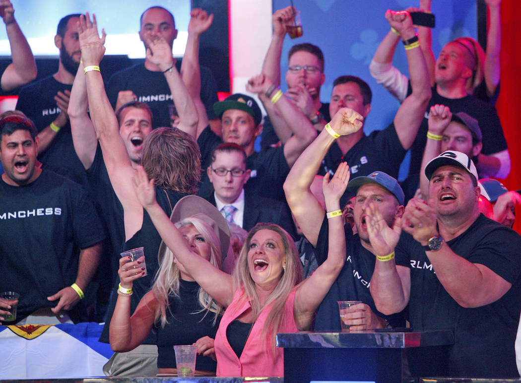 Fans of Alexander Livingston cheer him on at the main event final table at the World Series of ...