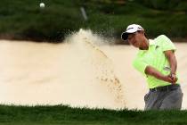 Collin Morikawa hits out of a bunker at 18 during the third round of the 3M Open golf tournamen ...