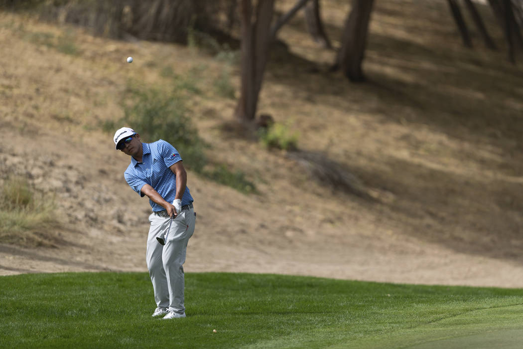 Kurt Kitayama of the U.S. chips onto the green on the 3rd hole during round one of the Dubai De ...