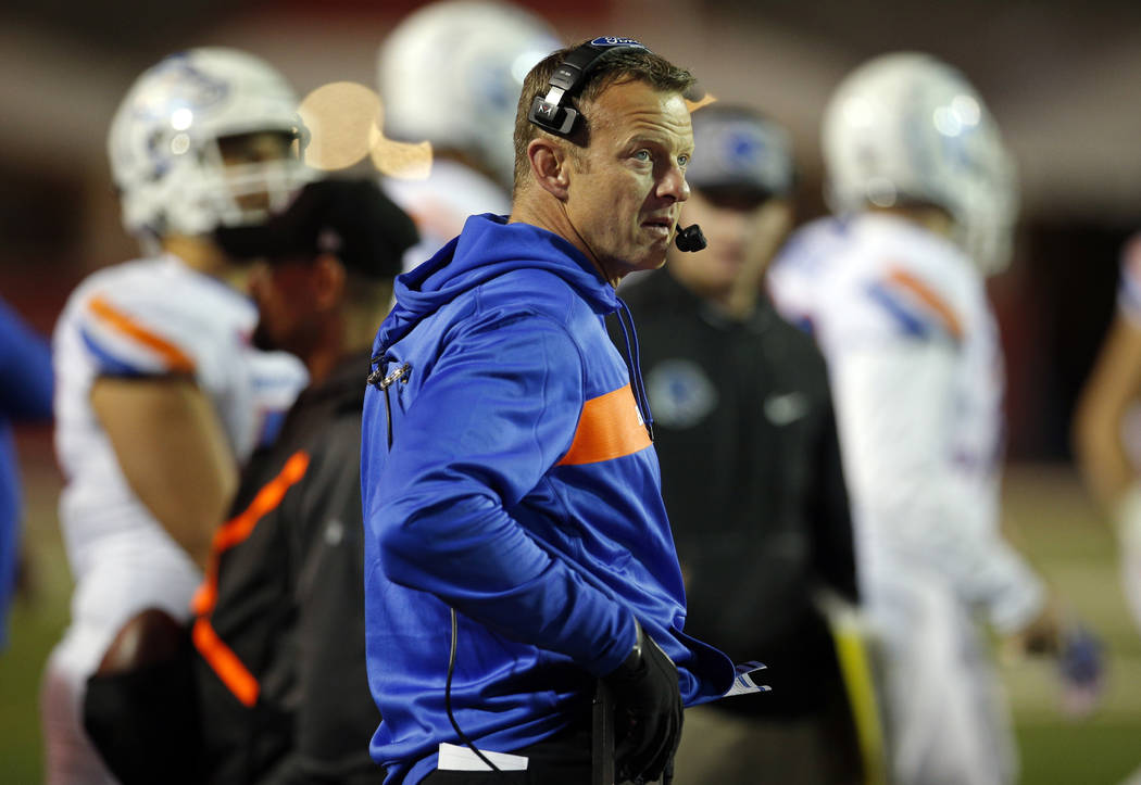 Boise State coach Bryan Harsin talks on his headphones during the second half of an NCAA colleg ...