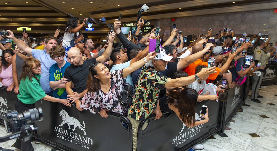 Fans push each other and ready their phones as boxer Manny Pacquiao enter the building during h ...