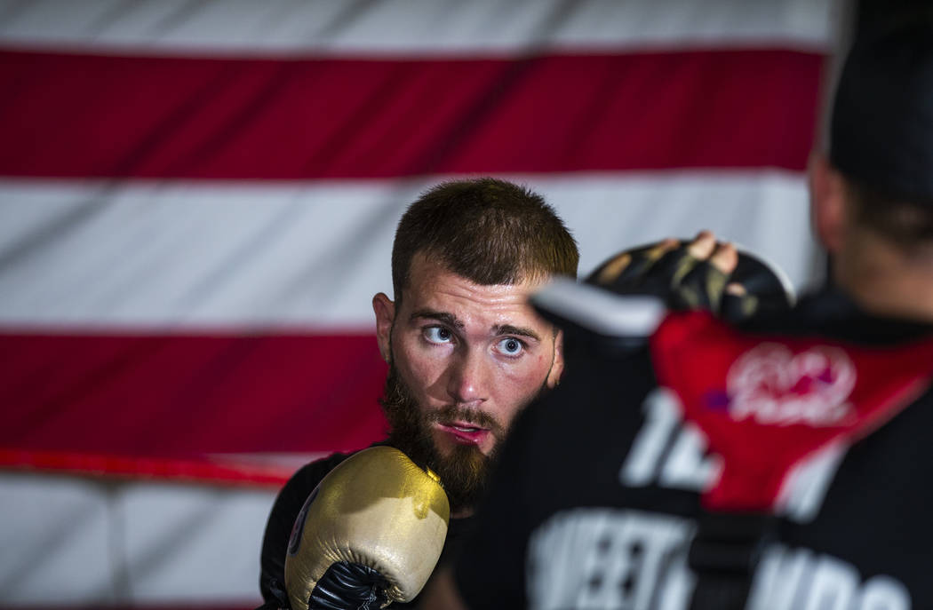 Boxer Caleb Plant, IBF super middleweight champion, punches a pad in the ring with trainer Just ...