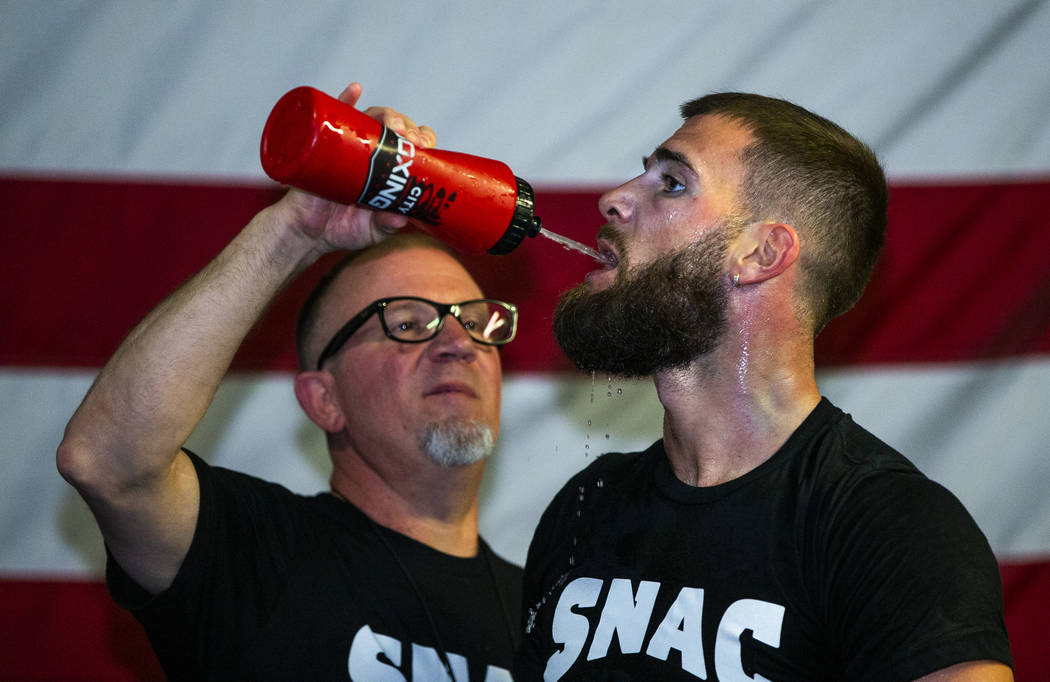 Boxer Caleb Plant, IBF super middleweight champion, right, is given some water by his dad Richi ...