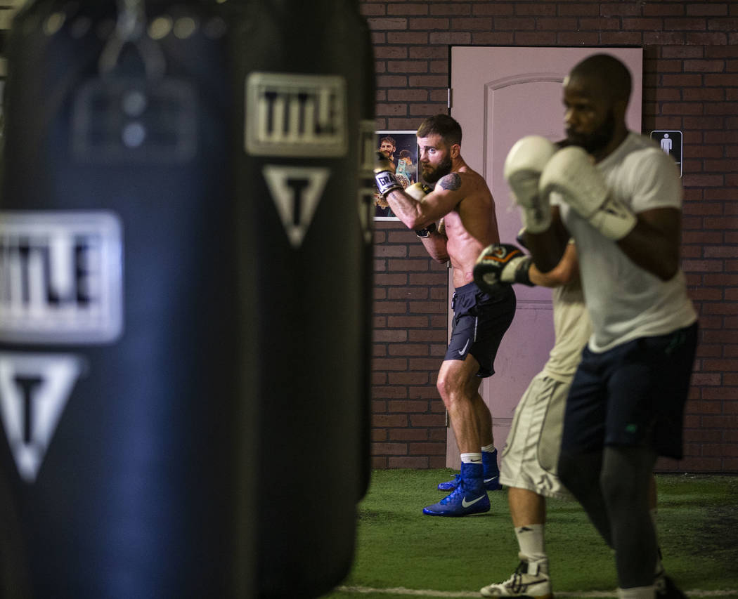 Boxer Caleb Plant, IBF super middleweight champion, rear, strikes the heavy bag during a media ...