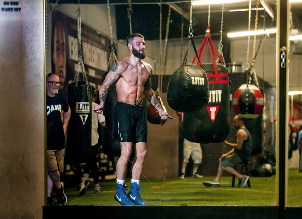 Boxer Caleb Plant, IBF super middleweight champion, right, jumps rope as his dad Richie, left, ...