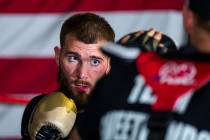 Boxer Caleb Plant, IBF super middleweight champion, punches a pad in the ring with trainer Just ...