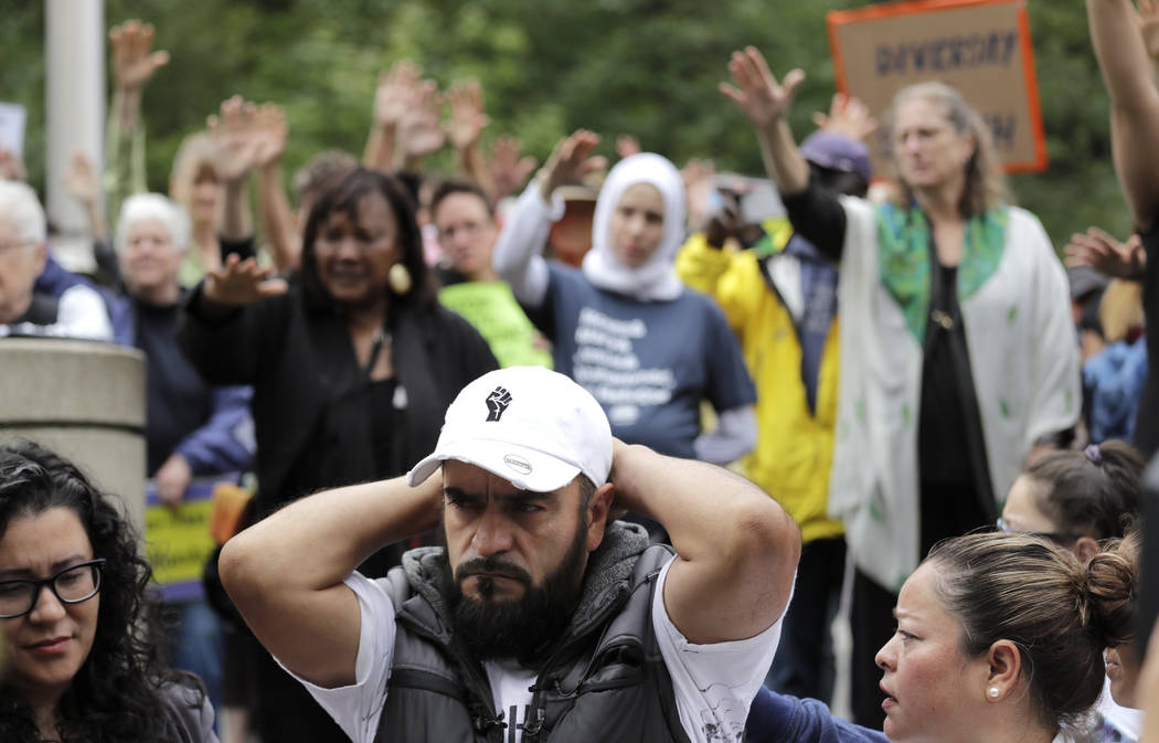 Jose Robles rests with his hands behind his head as supporters hold their arms toward him durin ...