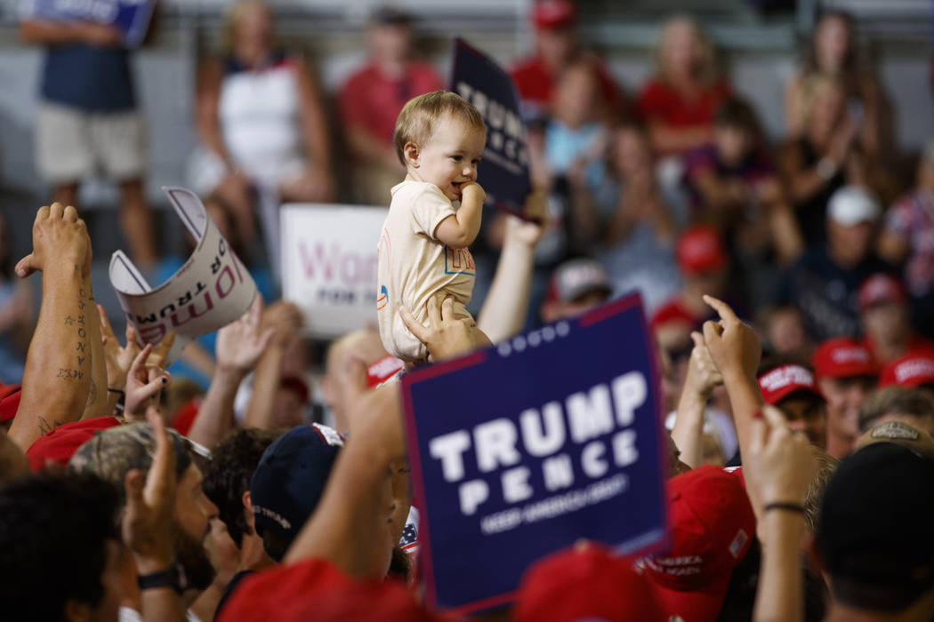 A baby is held high in the audience as President Donald Trump speaks at a campaign rally at Wil ...