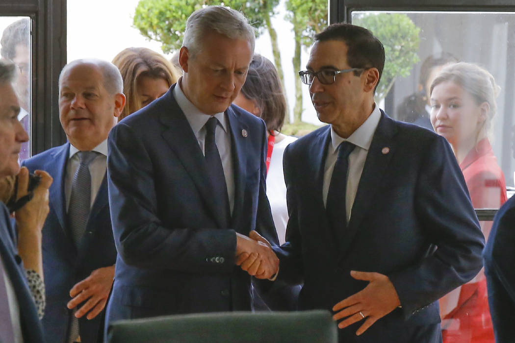 French Finance Minister Bruno Le Maire, left, shakes hands with US Treasury Secretary Steve Mnu ...