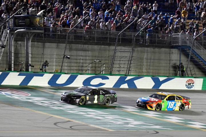 Kurt Busch crosses the finish line ahead of Kyle Busch (18) to win the NASCAR Cup Series auto r ...