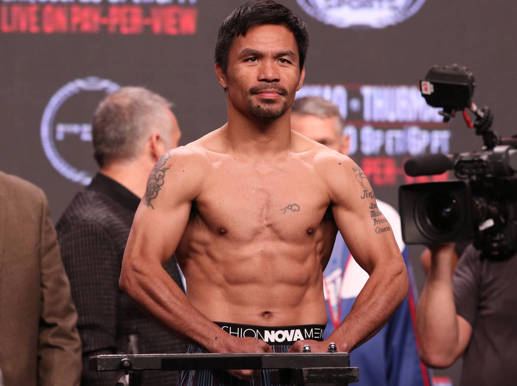 Manny Pacquiao poses on the scale during the official weigh-in at the MGM Grand Garden Arena in ...
