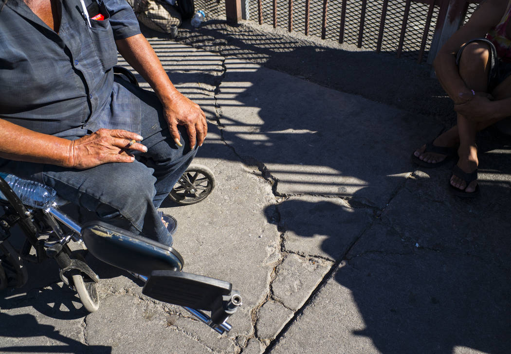 TJ, who declined to give his last name, left, talks about living homeless while waiting in line ...