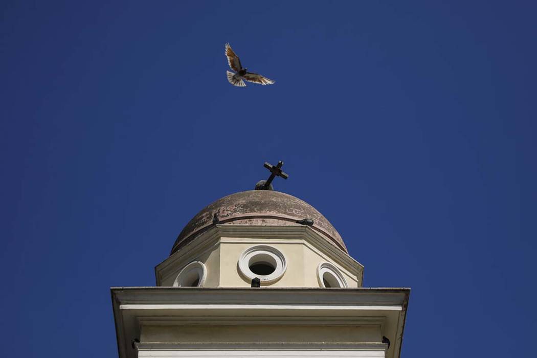 A pigeon flies next the damaged bell tower of Pantanassa church at the Monastiraki square follo ...