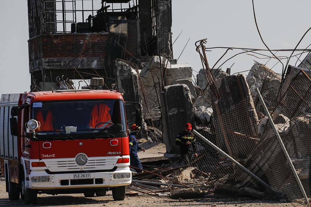 Firefighters search for trapped people at a damaged structure following an earthquake at the po ...