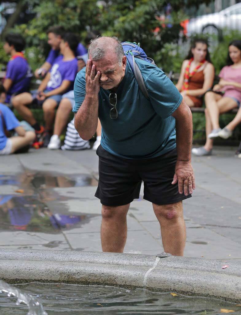 Russ Wilson splashes water on his face from a fountain in New York, Wednesday, July 17, 2019. T ...