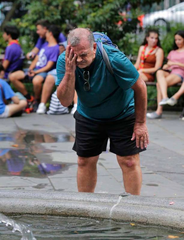 Russ Wilson splashes water on his face from a fountain in New York, Wednesday, July 17, 2019. T ...