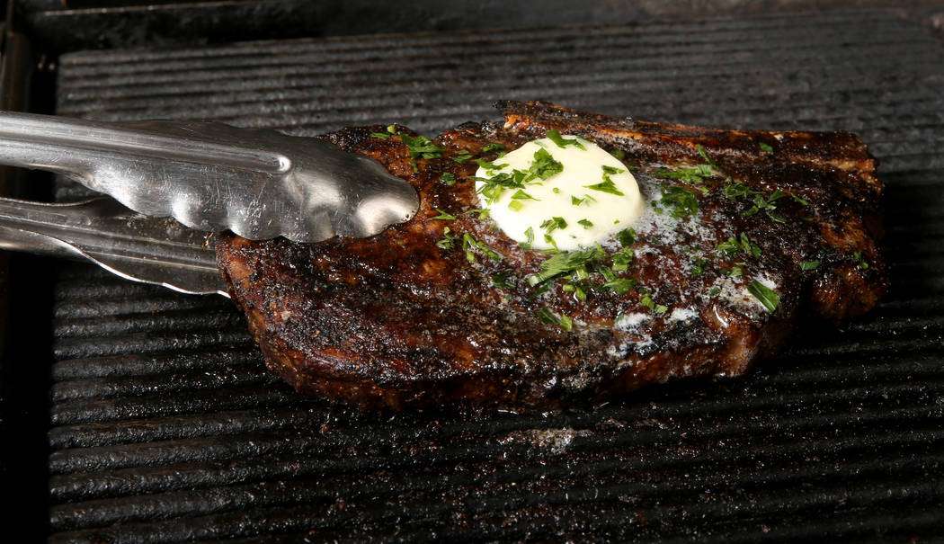 Creekstone Farm bone-in ribeye with maitre d' butter is prepared at Delmonico Steakhouse at The ...