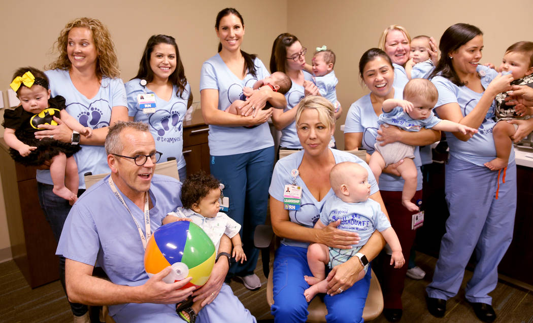 Neonatal Intensive Care Unit staff members attempt to pose with former patients during the firs ...