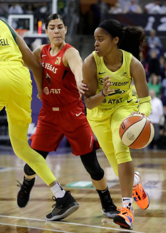 Seattle Storm's Jordin Canada, right, drives past Las Vegas Aces' Kelsey Plum during the first ...