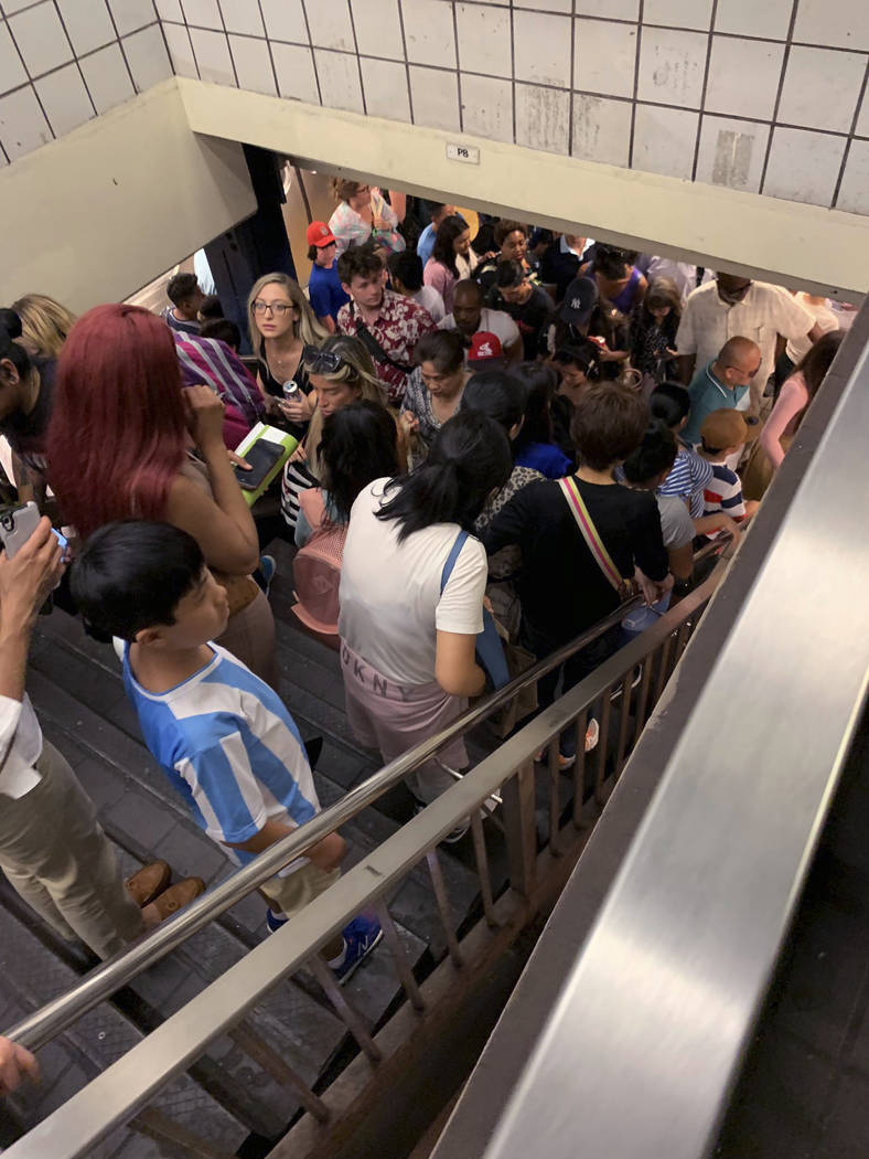 Commuters fill the stairs and line the platform at a New York City subway station as train serv ...