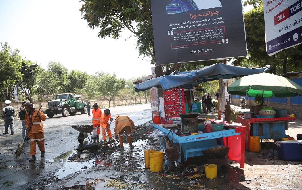 Workers clean the site of an explosion in Kabul, Afghanistan, Friday, July 19, 2019. A powerful ...