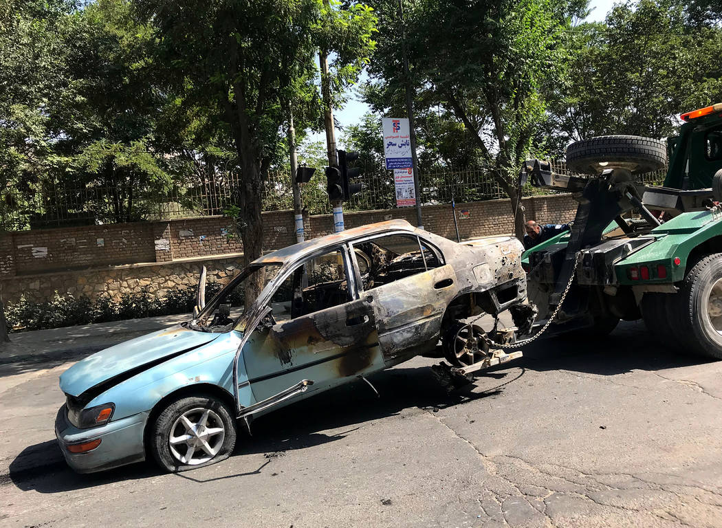 A damaged car is towed away from the site of an explosion in Kabul, Afghanistan, Friday, July 1 ...