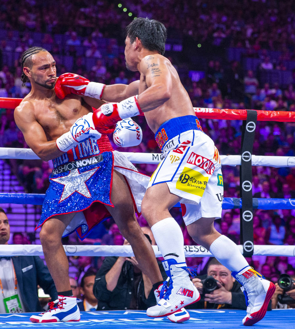 Keith Thurman is punches in the face by Manny Pacquiao during Round 2 of their WBA super welter ...