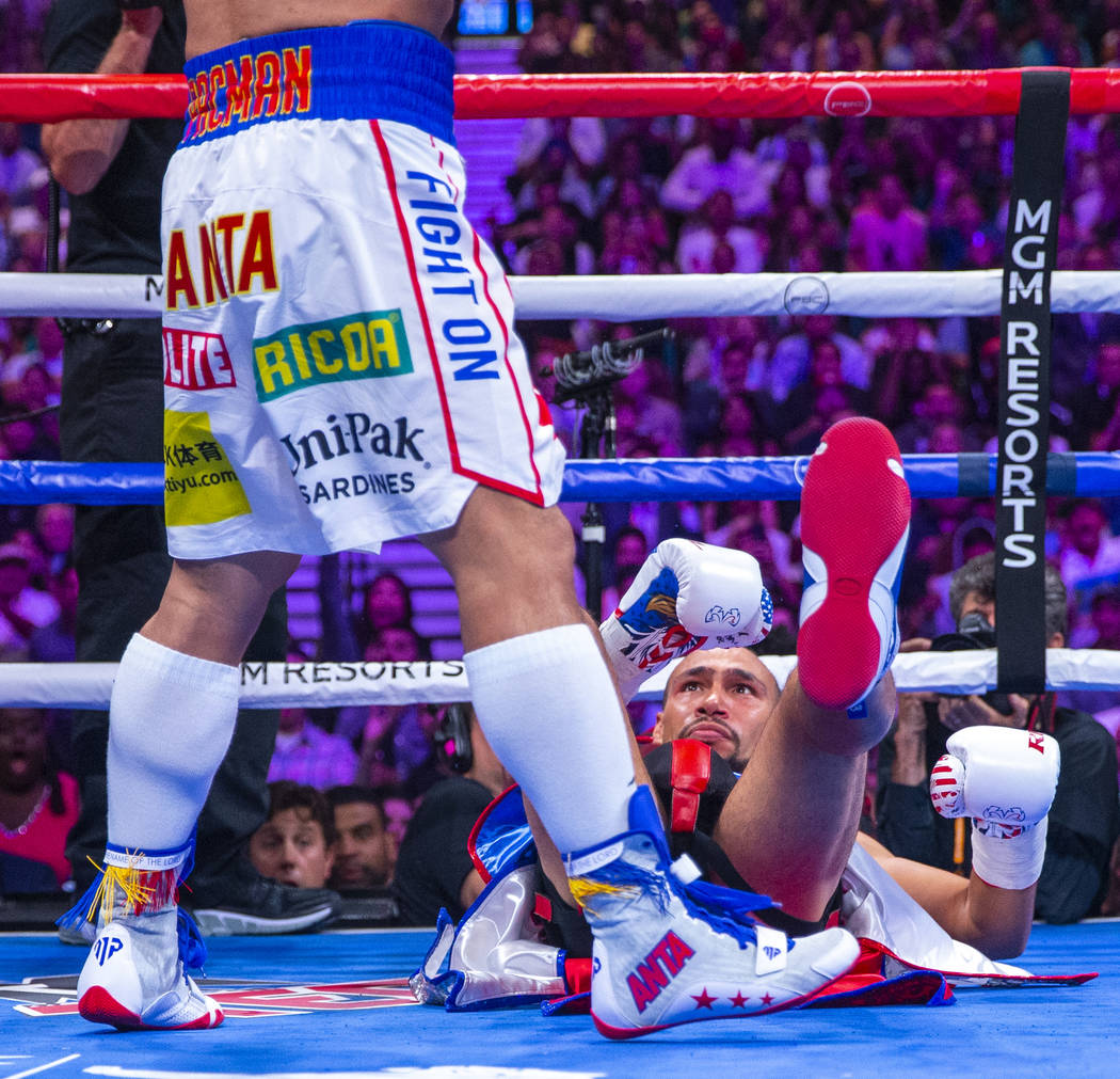 Manny Pacquiao, left, stands over Keith Thurman who went down in Round 1 during their WBA super ...