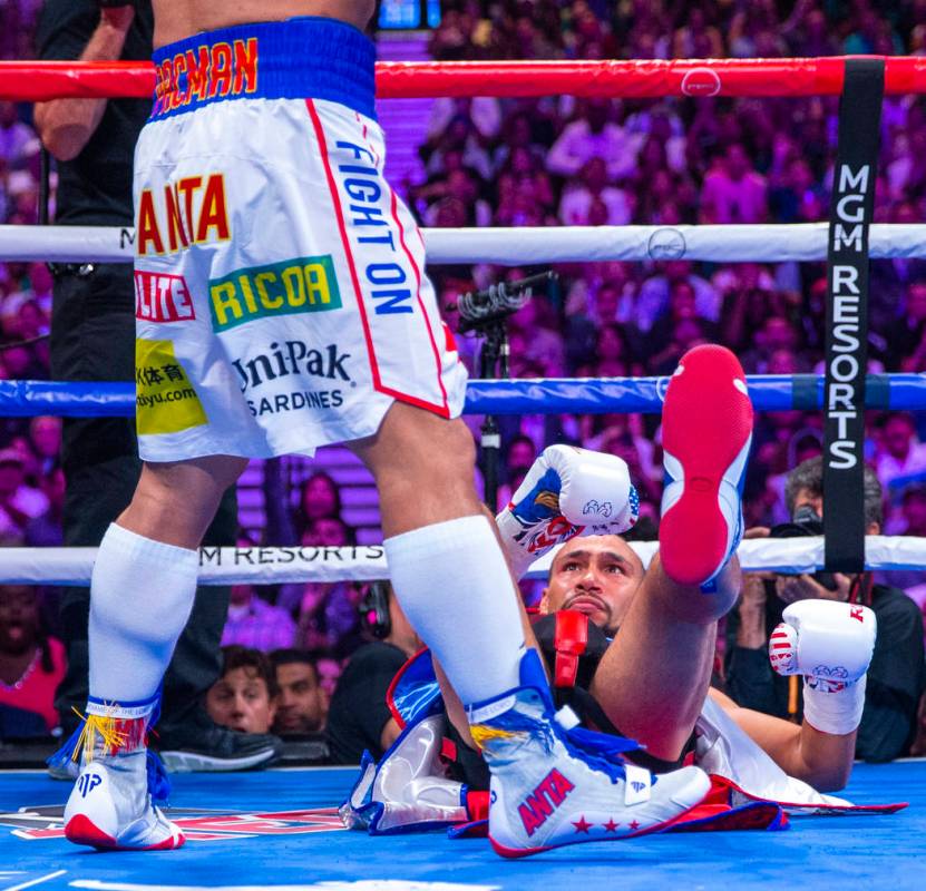 Manny Pacquiao, left, stands over Keith Thurman who went down in Round 1 during their WBA super ...