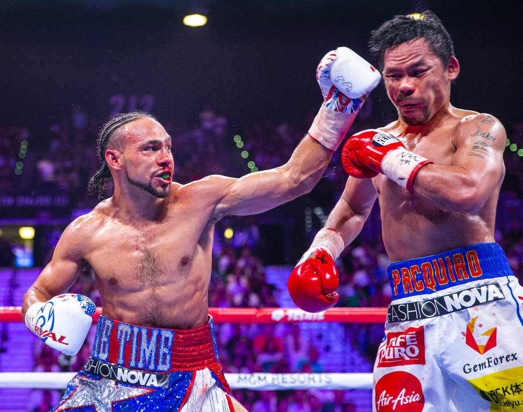 Keith Thurman, left, connects with a shot to the face of Manny Pacquiao during Round 6 of their ...