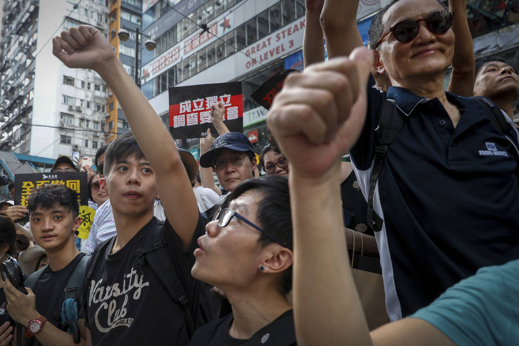 Protesters gestures during a march on a street in Hong Kong, Sunday, July 21, 2019. Thousands o ...