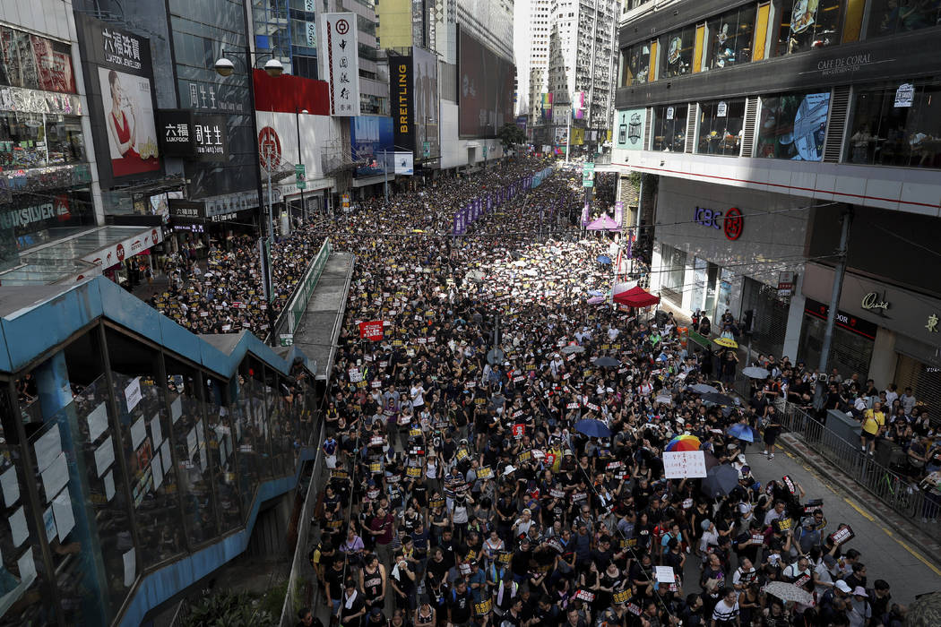 Protesters take part in a march on a street in Hong Kong, Sunday, July 21, 2019. Thousands of H ...