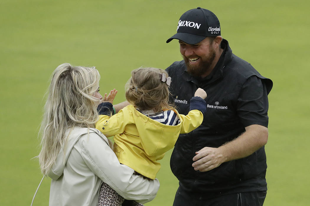 Ireland's Shane Lowry goes to kiss his daughter Iris and hugs his wife Wendy Honner on the 18th ...