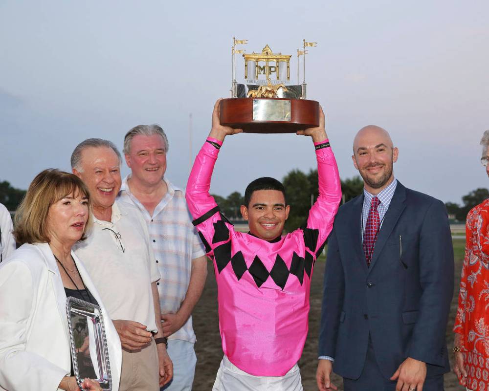 In this image provided by Ryan Denver/EQUI-PHOTO, Inc., Luis Saez, center, hoists the trophy af ...