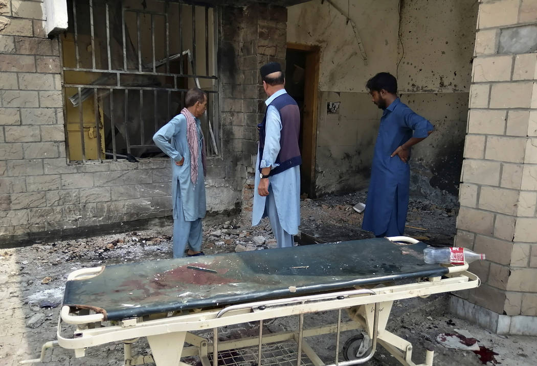 Hospital staff gather at the site of a bombing on an entrance of a hospital in Dera Ismail Khan ...