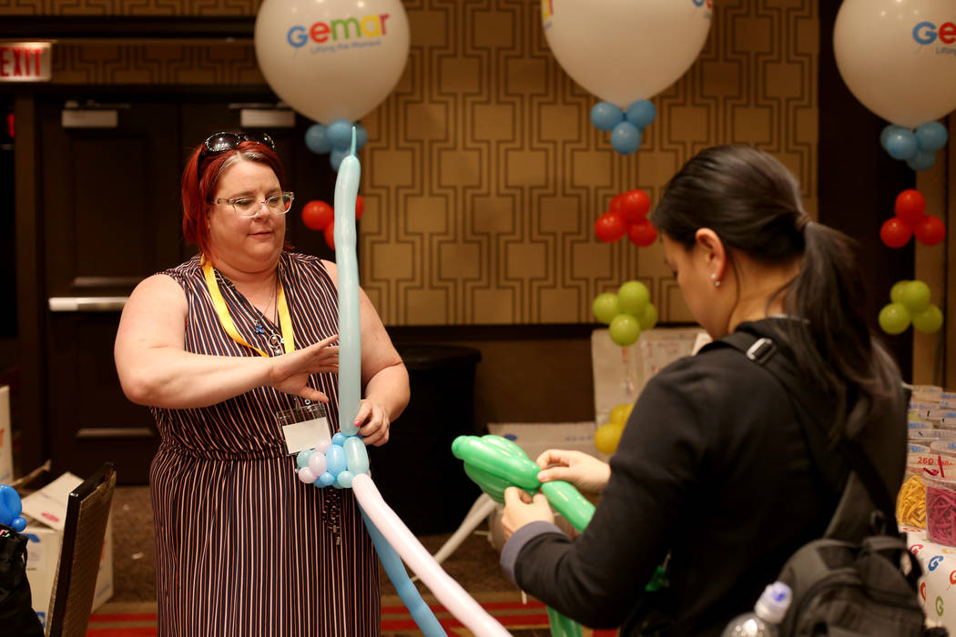 Becky Killoran of Canada, left, and Angie Tsang, of California, right, play with balloon twisti ...