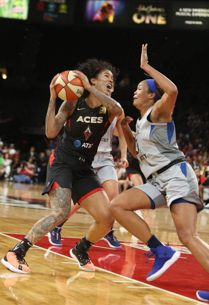 Las Vegas Aces forward Tamera Young, left, fights to the hoop against Minnesota Lynx forward Na ...