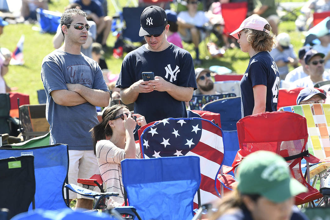Fans wait for the start of the National Baseball Hall of Fame induction ceremony at the Clark S ...