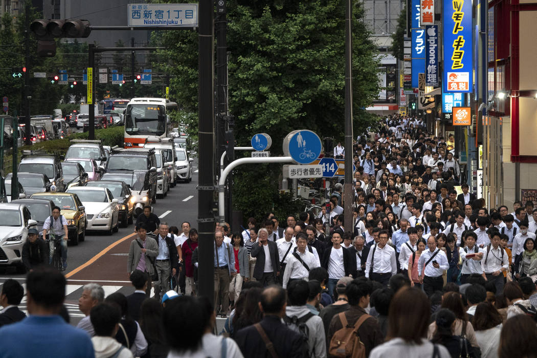 Commuters fill the street during the evening rush hours in the Shinjuku district of Tokyo, June ...