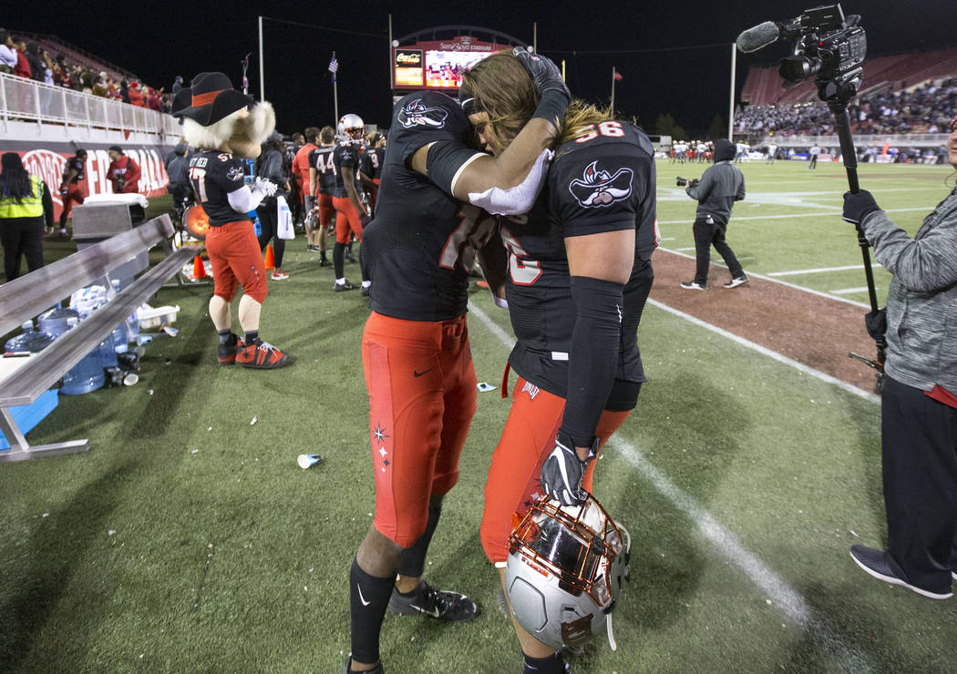 UNLV Rebels linebacker Javin White (16) and defensive lineman Roger Mann (56) share a hug after ...