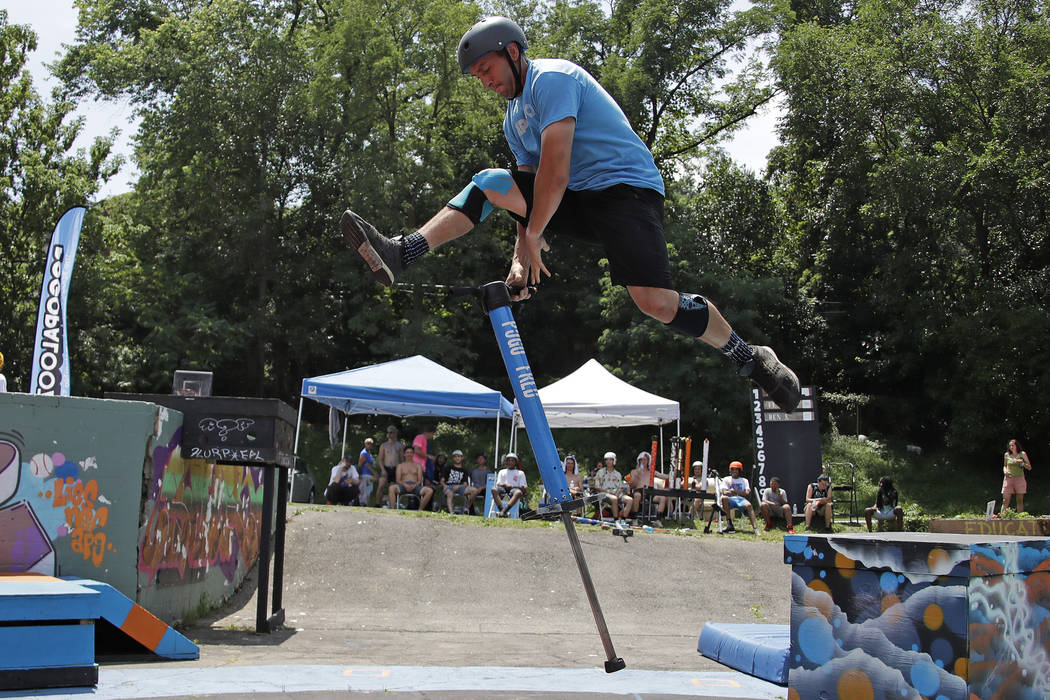 Fred Grzybowski, center, from Boston, does performs a dismount of his pogo stick during Pogopal ...