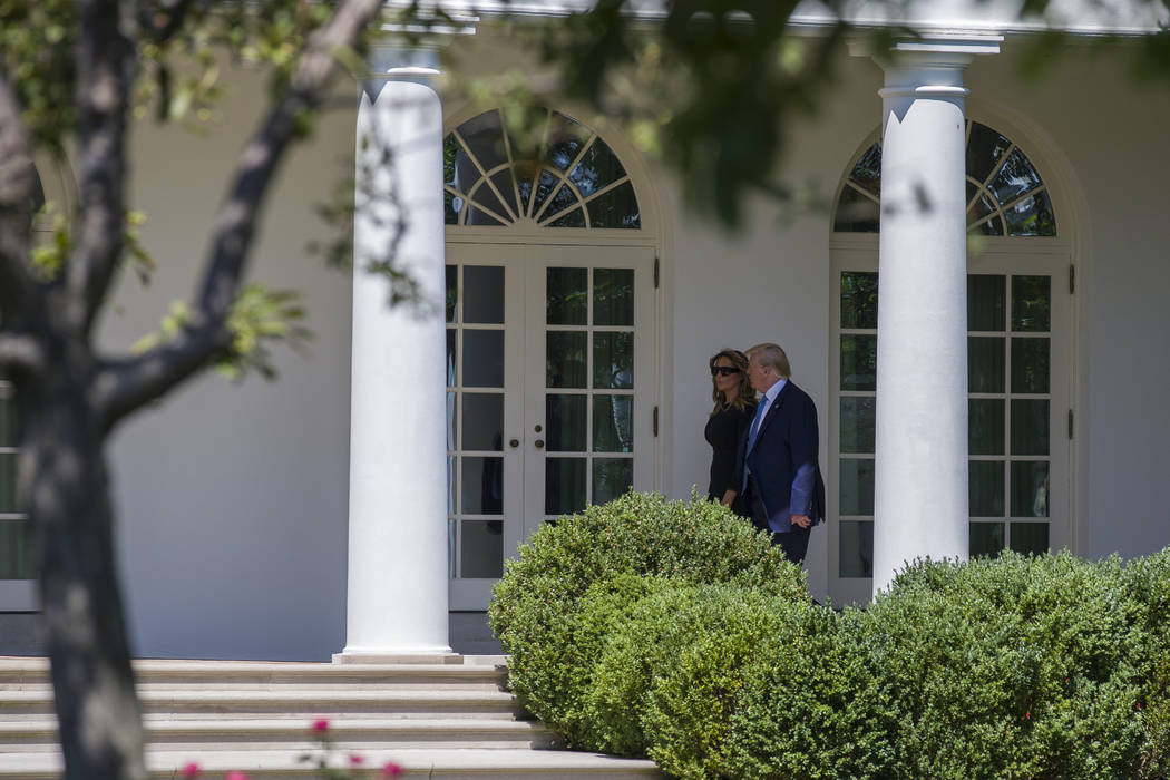 President Donald Trump, accompanied by first lady Melania Trump, walk the Colonnade on the way ...